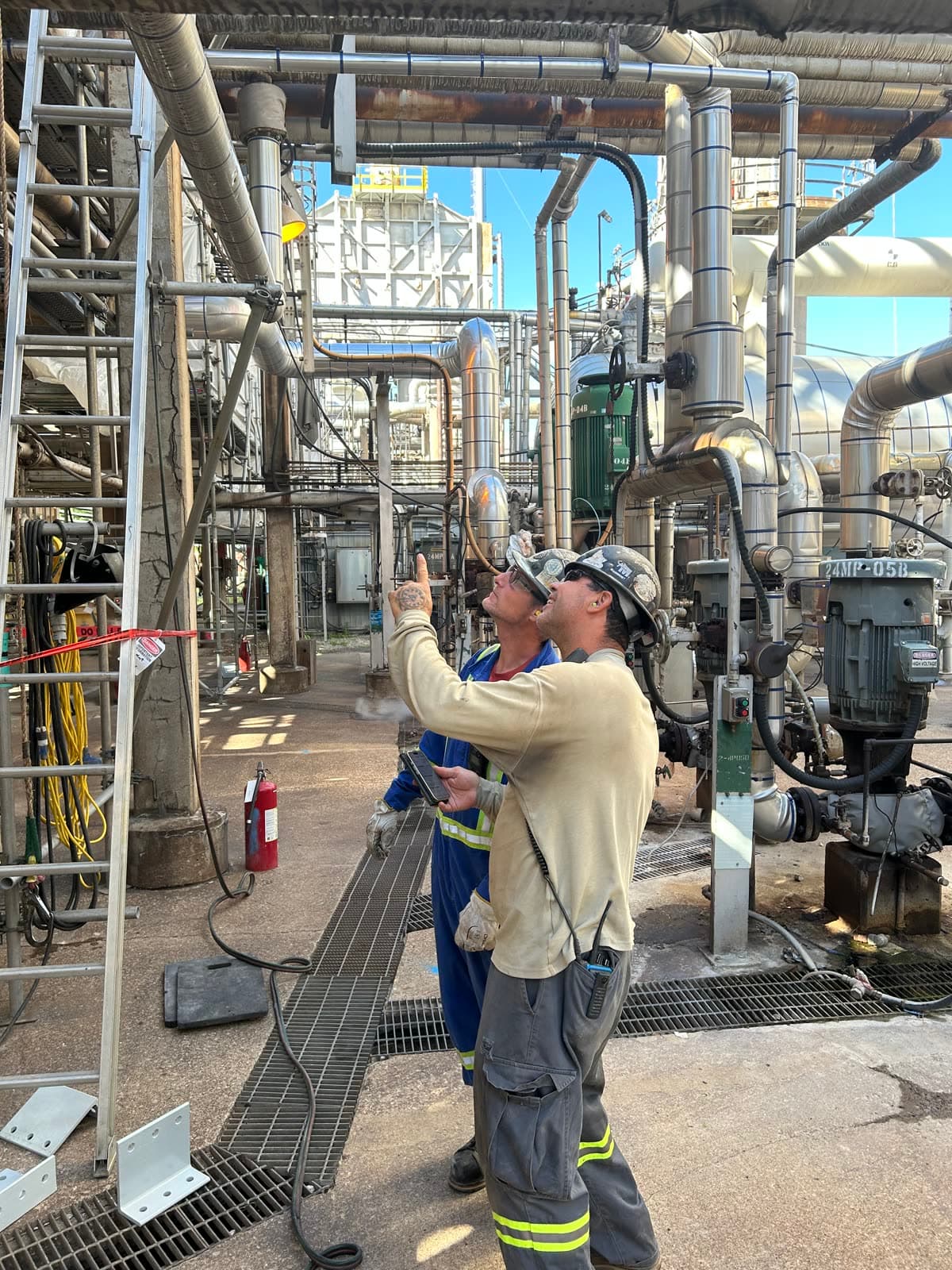 Crew at rotating equipment inside an operating plant